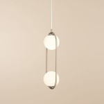 Lampa wisząca Riva 2-punktowa w kolorze beżowym, z metalowym stelażem w kształcie elipsy, zawieszona na białym przewodzie. Posiada dwa kuliste klosze z matowego szkła, emitujące miękkie światło, w prostym, nowoczesnym stylu.