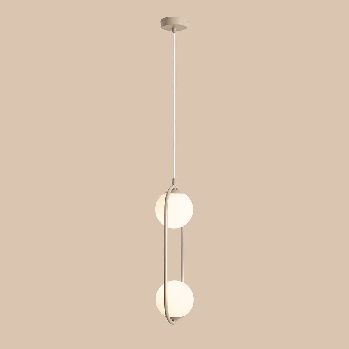 Lampa wisząca Riva 2-punktowa w kolorze beżowym z dwoma okrągłymi kloszami z matowego szkła, zawieszona na cienkim, białym sznurku. Produkt ma nowoczesny design, z metalową ramą o delikatnych kształtach.