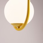 Lampa wisząca Riva 2-punktowa w kolorze żółtym, z białym, okrągłym kloszem. Ujęcie z dołu, pokazujące metalowy uchwyt w kształcie półokręgu. Tło w odcieniu szaro-beżowym, co podkreśla kolor lampy.