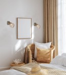 Kinkiet Rodia 1-punktowy w kolorze patyny z bursztynowym kloszem. Zamontowany na ścianie obok ramki na zdjęcia, w jasnym wnętrzu sypialni z naturalnymi tkaninami. Oświetlenie w stylu nowoczesnym, z widoczną żarówką w kloszu.