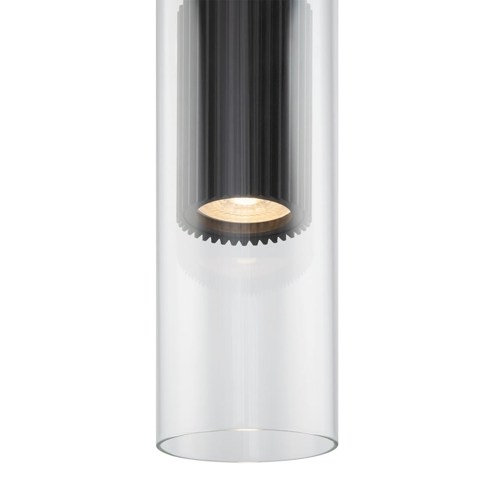 Lampa wisząca Dynamics 1-punktowa w kolorze czarnym. Kształt cylindryczny z przezroczystym kloszem, wewnątrz widoczny czarny element z rowkami. Źródło światła na dole, zapewniające punktowe oświetlenie. Montaż sufitowy.