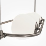 Lampa wisząca Erich 3-punktowa w kolorze niklu, z trzema zaokrąglonymi kloszami w odcieniu białym. Ujęcie z boku, pokazujące metalową konstrukcję oraz gładkie, lekko wypukłe klosze, umieszczone na prostokątnej ramie.