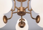 Lampa sufitowa Erich 10-punktowa w kolorze mosiądzu, z białymi, okrągłymi kloszami. Ujęcie z dołu, ukazujące szczegóły konstrukcji i uchwytów, z centralnym elementem mocującym. Idealna do nowoczesnych wnętrz.