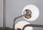 Lampa sufitowa Erich 10-punktowa w kolorze niklu. Składa się z kilku metalowych ramion, z których zwisają okrągłe, mleczne klosze. Ujęcie z góry, uwydatniające detale konstrukcji oraz gładką fakturę kloszy. Tło w jasnym odcieniu.
