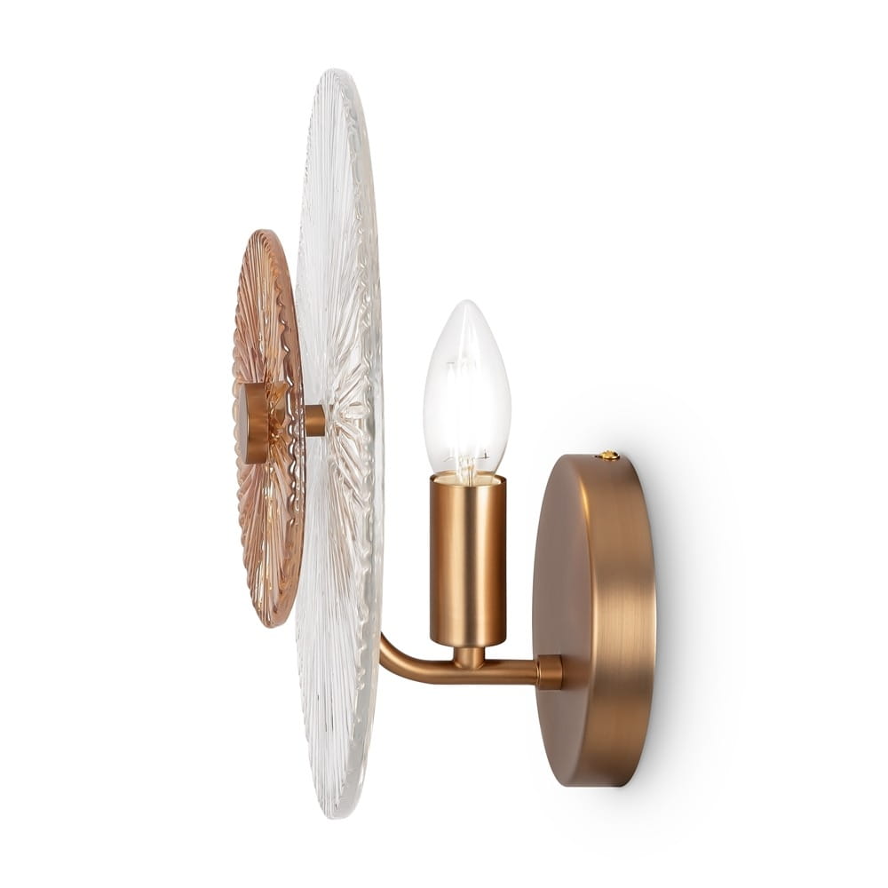 Kinkiet Aster 1-punktowy w kolorze złotym z okrągłym, przezroczystym kloszem oraz detalami w odcieniu miedzi. Lampa z pojedynczym źródłem światła, montowana na ścianie, z eleganckim wykończeniem i teksturą klosza.