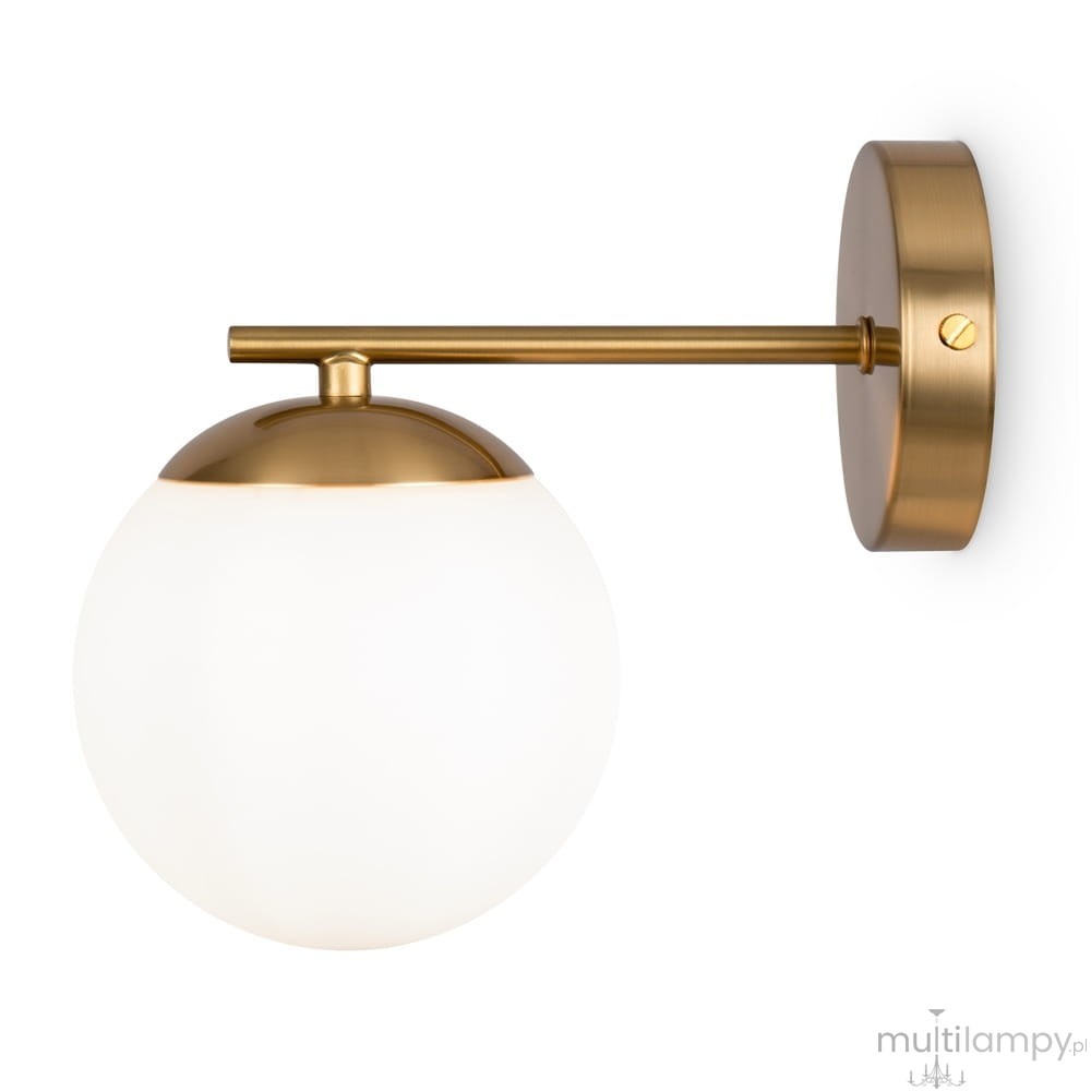 Kinkiet Marble 1-punktowy w kolorze mosiądzu z okrągłą, matową, białą szklaną kloszem. Produkt zamontowany na ścianie, z metalową podstawą w kształcie okręgu. Kąt ujęcia frontalny, ukazujący szczegóły konstrukcyjne oraz wykończenia.