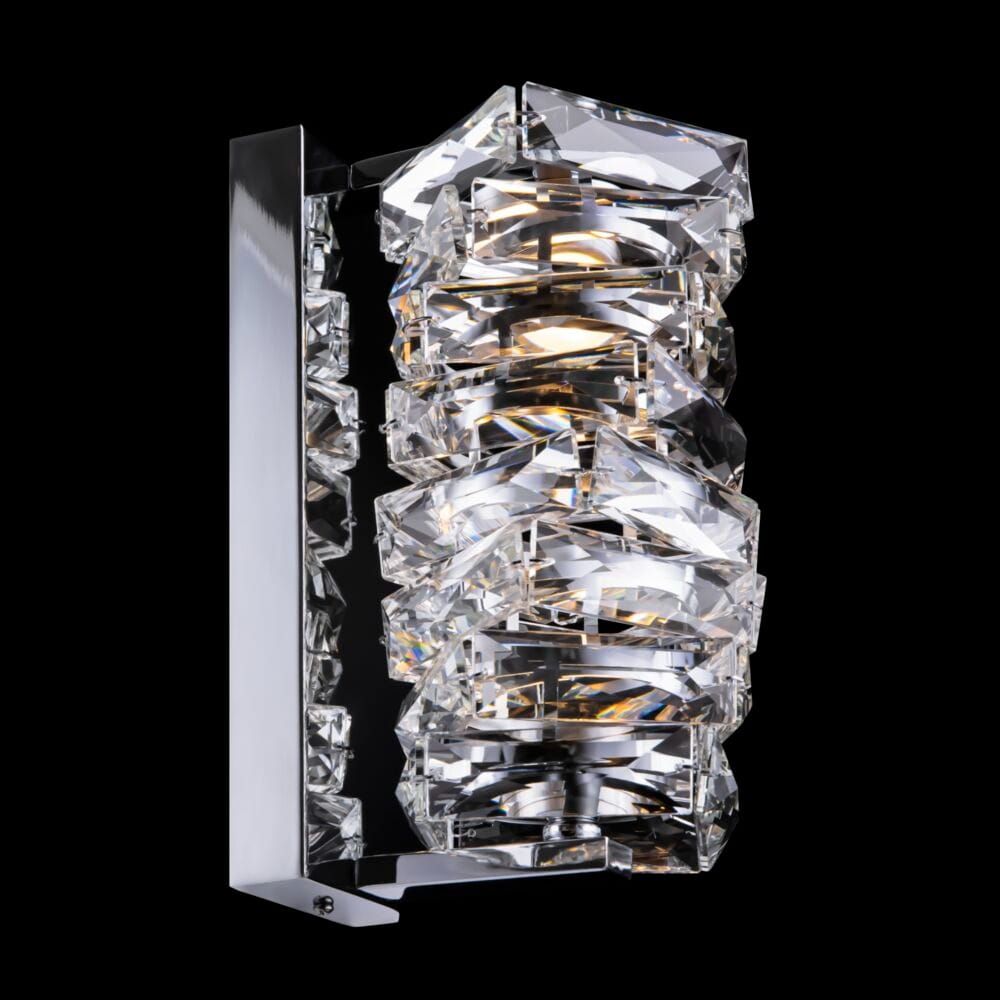 Kinkiet Coil LED 1-punktowy w chromowanej obudowie z kryształowymi elementami. Oświetlenie w formie pionowej, z wyraźnie widocznymi, geometrycznymi wzorami. Tło czarne, co podkreśla blask kryształu.