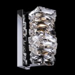 Kinkiet Coil LED 1-punktowy w chromowanej obudowie z kryształowymi elementami. Oświetlenie w formie pionowej, z wyraźnie widocznymi, geometrycznymi wzorami. Tło czarne, co podkreśla blask kryształu.