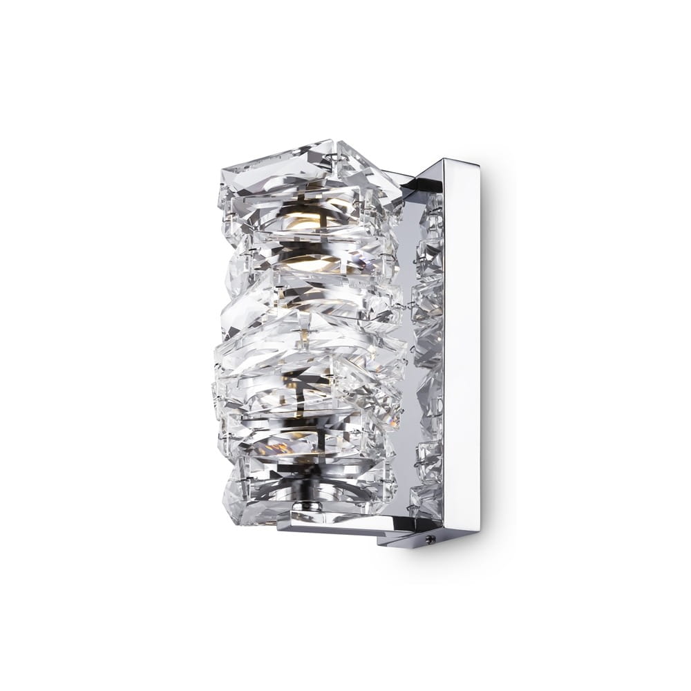 Kinkiet Coil LED 1-punktowy w kolorze chromu. Lampa z przezroczystymi, teksturowanymi elementami, umocowana na prostokątnej, metalowej podstawie. Ujęcie z boku, ukazujące detale i fakturę kryształowych akcentów.