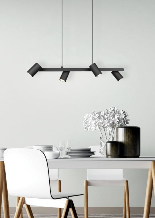 Czarna lampa wisząca Marley 4-punktowa z metalowymi kloszami w formie cylindrów, zawieszona nad stołem. Lampa ma prostą, minimalistyczną konstrukcję i jest umieszczona w jasnym wnętrzu z białym stołem i dekoracjami.