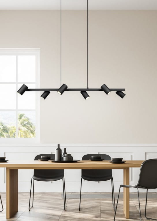 Lampa wisząca Marley 6-punktowa w kolorze czarnym, z sześcioma okrągłymi kloszami zamontowanymi na prostokątnej belce. Zawieszona nad drewnianym stołem w jasnym wnętrzu, z oknem w tle. Idealna do nowoczesnych aranżacji.