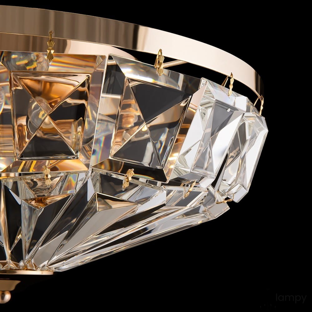 Złota lampa sufitowa 6-punktowa z przezroczystymi, diamentowymi kryształami, wisząca na złotym stelażu. Detal z bliska pokazuje geometryczne kształty i błyszczące wykończenie, w eleganckim, nowoczesnym stylu. Tło czarne.