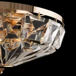 Złota lampa sufitowa 6-punktowa z przezroczystymi, diamentowymi kryształami, wisząca na złotym stelażu. Detal z bliska pokazuje geometryczne kształty i błyszczące wykończenie, w eleganckim, nowoczesnym stylu. Tło czarne.