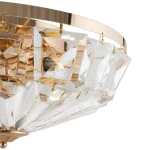 Lampa sufitowa Facet 6-punktowa w kolorze złotym, z kryształowymi zdobieniami w kształcie piramid. Widok z góry, ukazujący elegancki design oraz detale mocowania. Szklane elementy odbijają światło, tworząc efektowne refleksy.