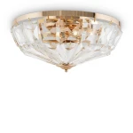 Lampa sufitowa 6-punktowa w kolorze złotym z przezroczystymi, szklanymi elementami w kształcie piramid. Ujęcie z dołu, prezentująca elegancki design i efektowne odbicie światła. Montowana pod sufitem, idealna do nowoczesnych wnętrz.