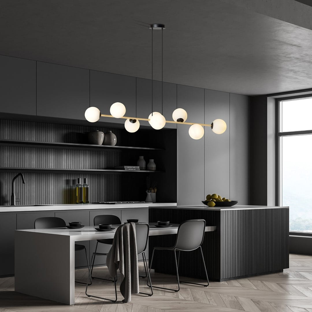 Lampa wisząca Gravity 8-punktowa w kolorze czarnym i złotym z opalowymi kloszami. Zawieszona na cienkich linkach, z okrągłymi kloszami rozmieszczonymi na prostokątnej ramie. Umieszczona nad stołem w nowoczesnej kuchni, w minimalistycznym otoczeniu.