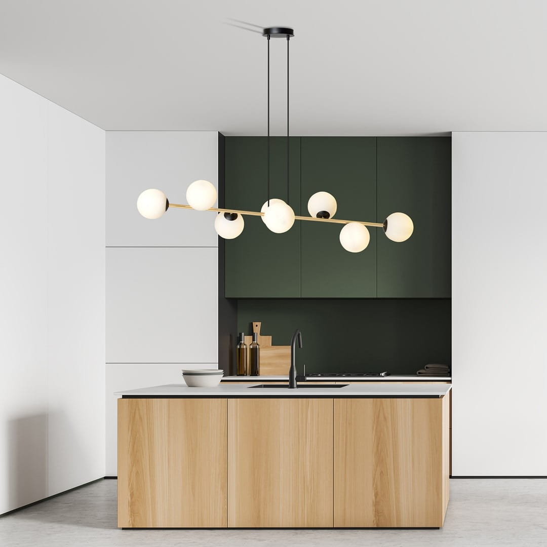 Lampa wisząca Gravity 8-punktowa w kolorze czarnym i złotym z opalowymi kloszami, zawieszona w nowoczesnej kuchni. Produkt ma prosty, geometryczny kształt, z pięcioma okrągłymi kloszami na cienkich prętach. Tło w odcieniach bieli i zieleni.
