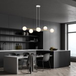 Lampa wisząca Gravity 6-punktowa w kolorze białym, złotym i opalowym. Oświetlenie w formie sześciu opalowych kul zawieszonych na złotej rurce, umieszczone na tle nowoczesnej kuchni z ciemnymi meblami i dużymi oknami.