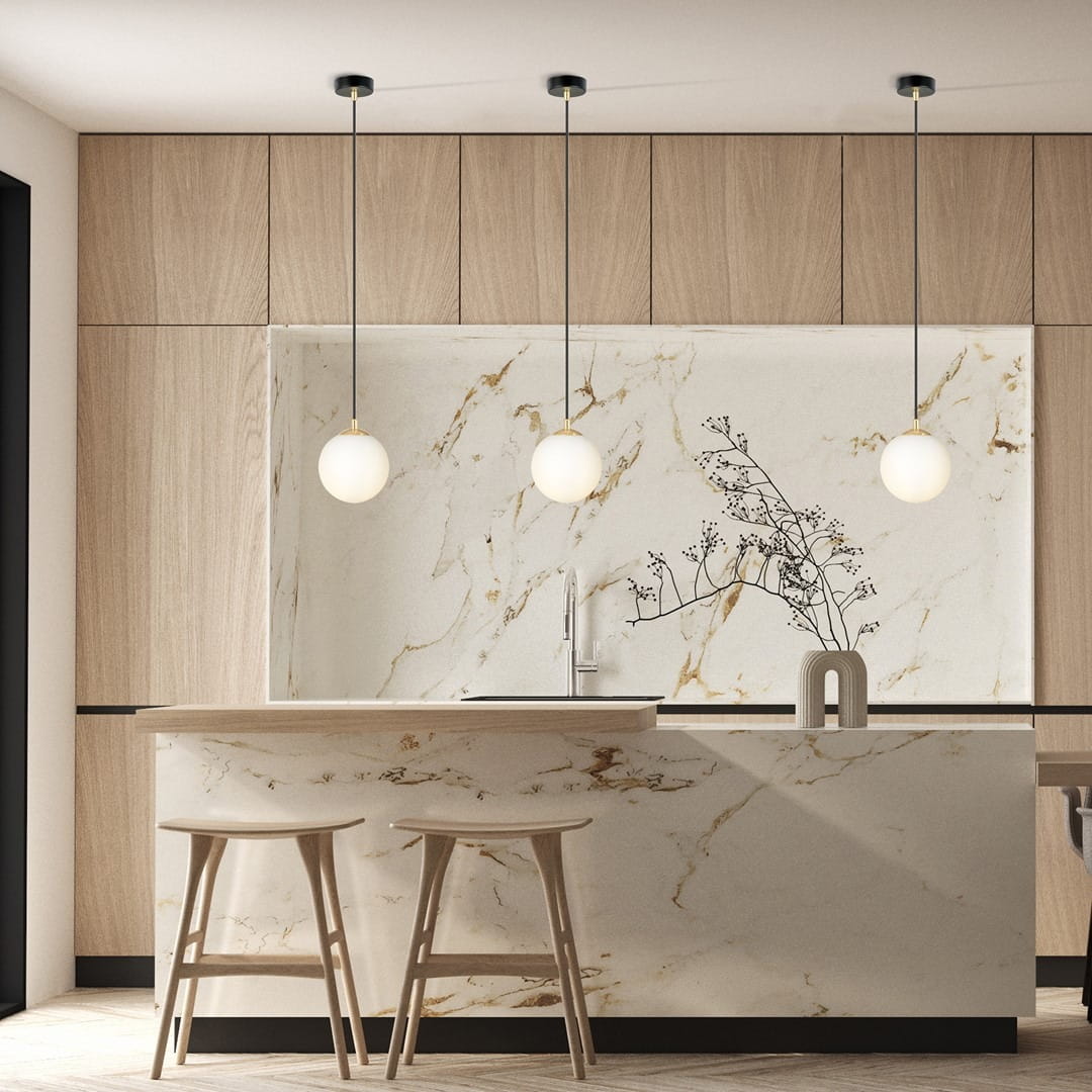 Lampa wisząca Royal 1-punktowa w kolorze czarnym i złotym, z okrągłym, białym kloszem. Zawieszona na cienkim, regulowanym kablu, idealna do nowoczesnych wnętrz. Widoczna w aranżacji kuchennej z drewnianym blatem i minimalistycznym wystrojem.