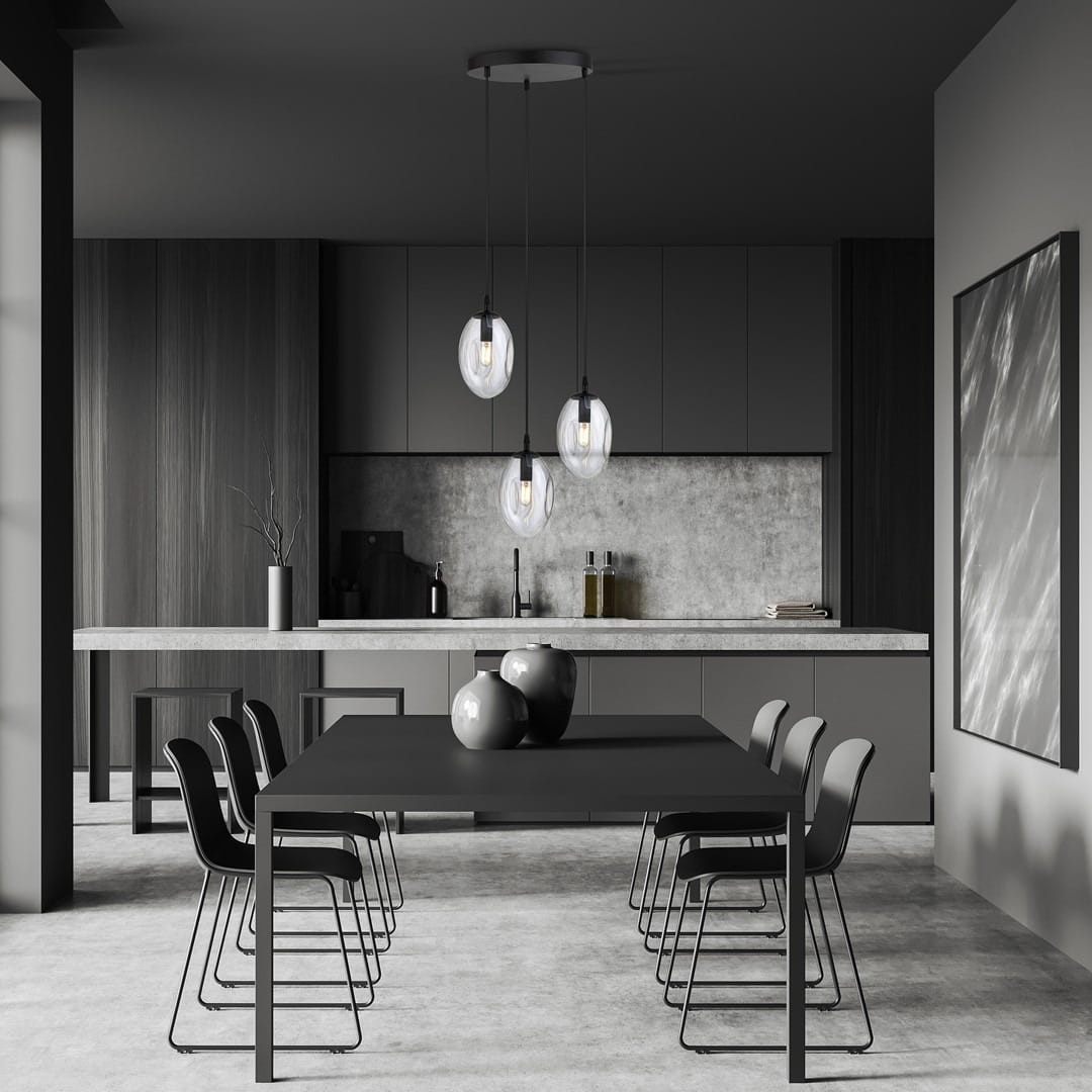 Czarna lampa wisząca 3-punktowa Astral z transparentnymi kloszami, zawieszona na trzech linkach. Wnętrze nowoczesnej kuchni z betonowym blatem i czarnym stołem, otoczona metalowymi krzesłami.