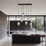 Lampa wisząca Astral 6-punktowa w kolorze czarnym i grafitowym, z sześcioma szklanymi kloszami w kształcie owalnym, zawieszona na cienkich linkach. Ujęcie z góry, w nowoczesnej kuchni z dużymi oknami.