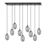 Lampa wisząca Astral 9-punktowa w kolorze czarnym i grafitowym. Składa się z dziewięciu szklanych kloszy w kształcie owalnym, zawieszonych na cienkich czarnych linkach, umocowanych na prostokątnej podstawie.