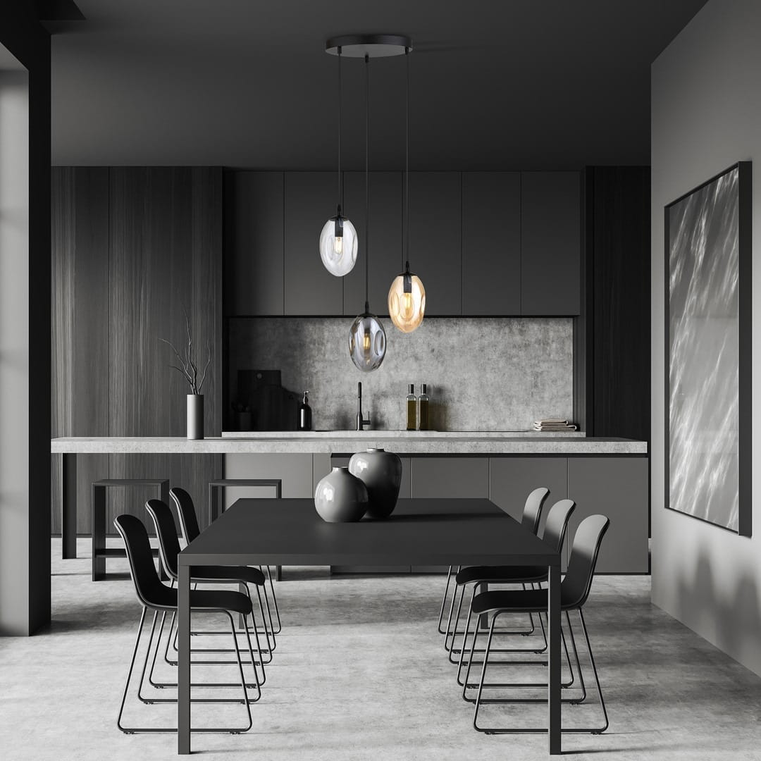 Lampa wisząca Astral 3-punktowa w kolorze czarnym z multikolorowymi kloszami, zawieszona na długich kablach, w nowoczesnej kuchni. W tle widoczne szare meble i stół z czarnymi krzesłami.