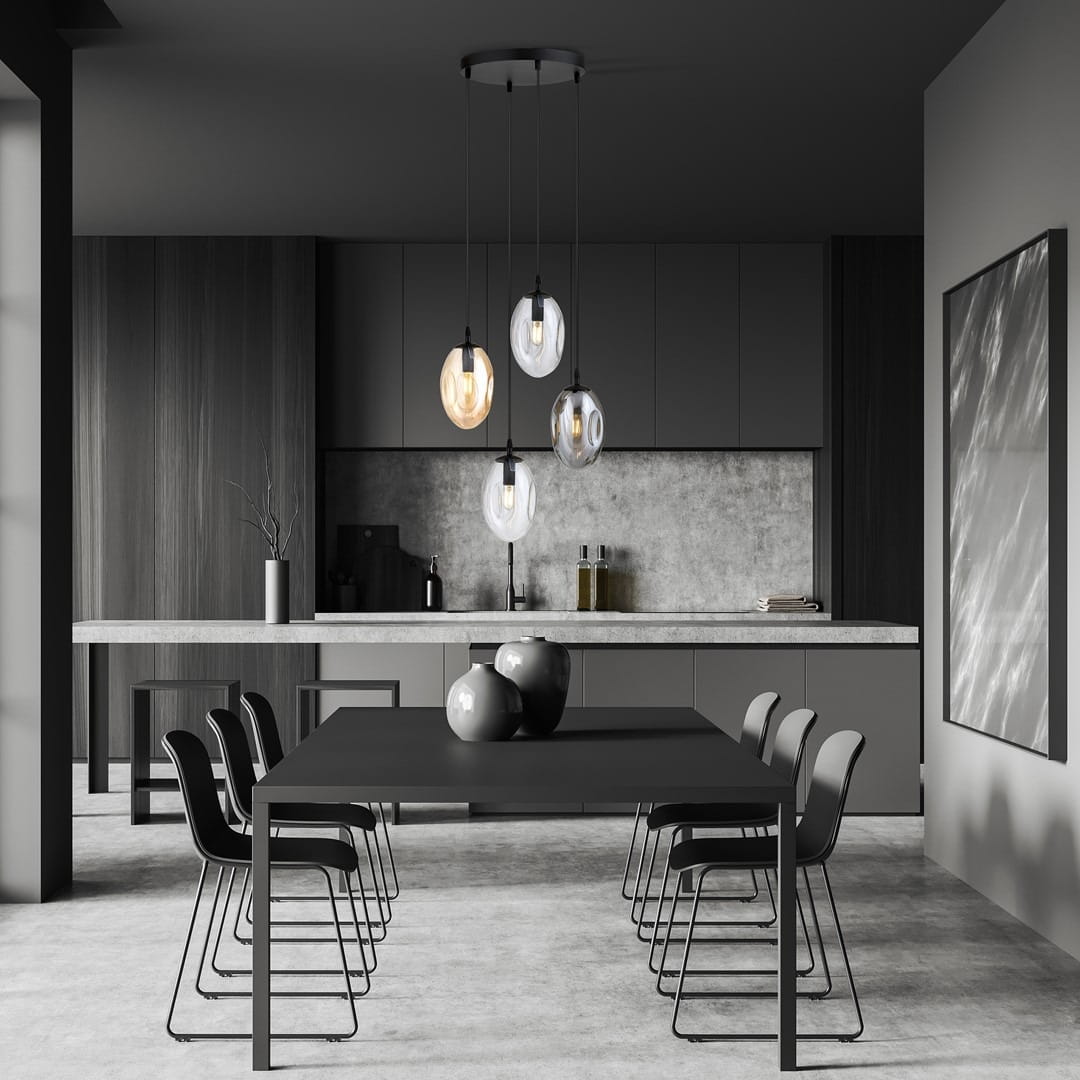 Czarna lampa wisząca Astral 4-punktowa z multikolorowymi kloszami w kształcie owalnym, zawieszona na cienkich linkach. Ujęcie z góry w nowoczesnej kuchni z drewnianymi i betonowymi akcentami. Na stole czarne naczynia i krzesła w minimalistycznym stylu.
