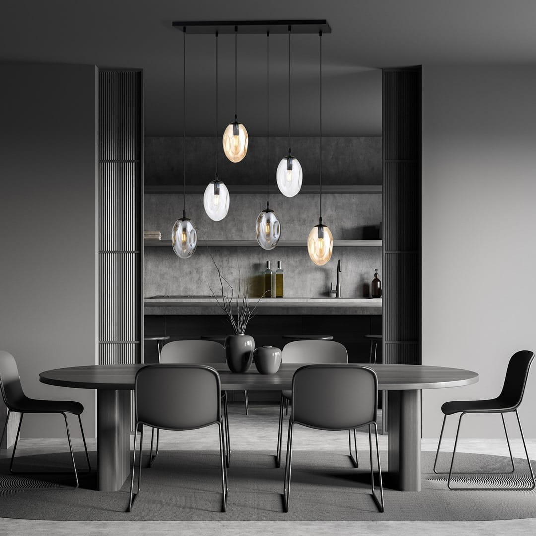 Lampa wisząca Astral 6-punktowa w kolorze czarnym z multikolorowymi kloszami, zawieszona na prostokątnej podstawie. Klosze mają różne kształty i kolory, w tym przezroczyste i matowe. Produkt umieszczony nad okrągłym stołem w nowoczesnym wnętrzu.