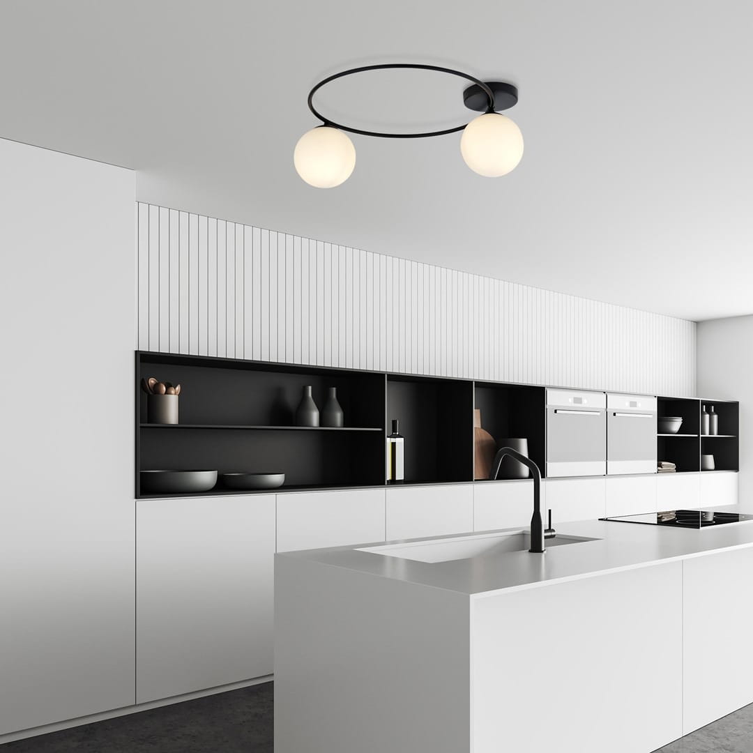 Lampa sufitowa Sopra 2-punktowa w kolorze czarnym z opalowymi kloszami, zawieszona na okrągłej podstawie, umieszczona w nowoczesnej kuchni z białymi meblami i czarnymi półkami. Oświetlenie skierowane w dół, tworzy minimalistyczny efekt.
