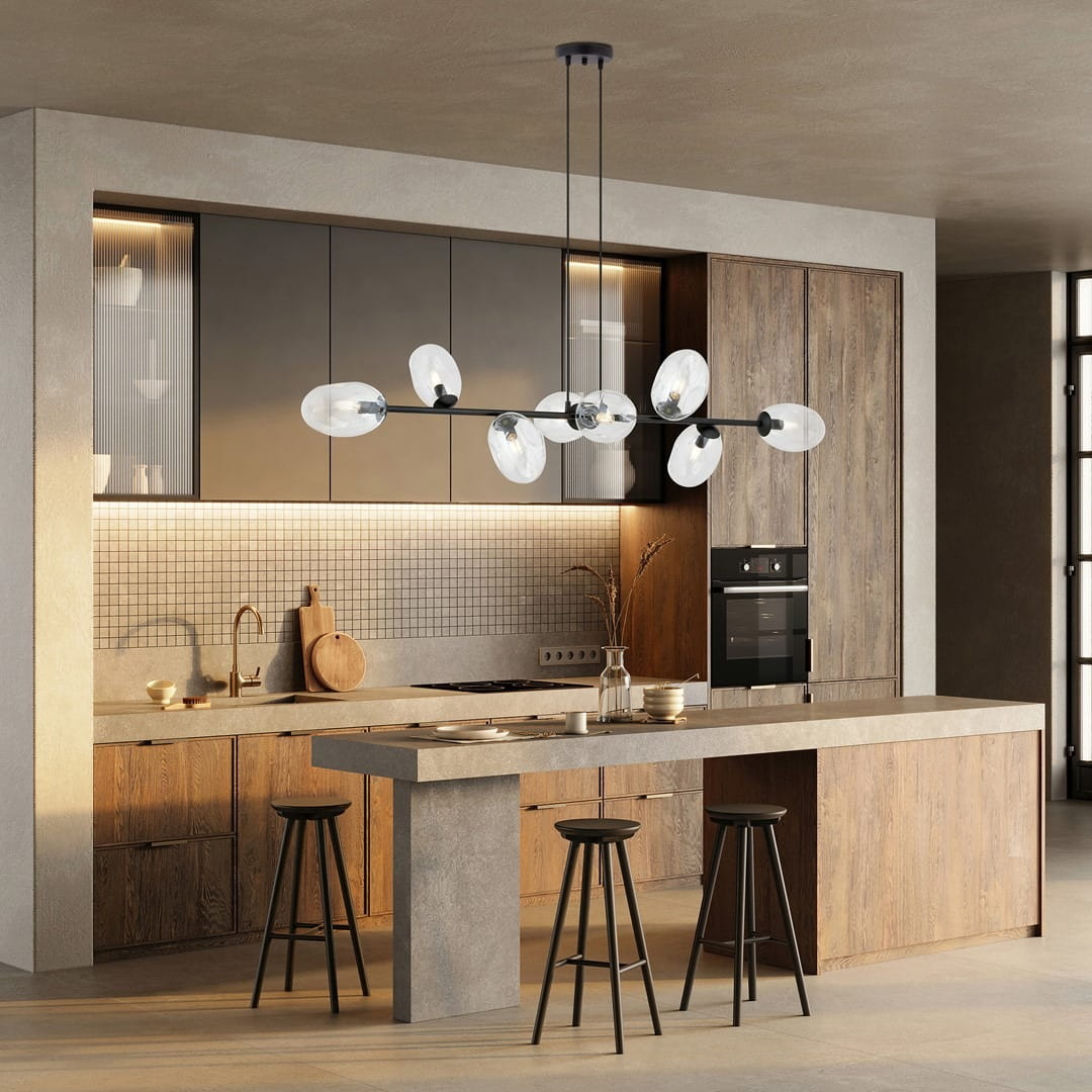 Lampa wisząca Pandora 8-punktowa w kolorze czarnym i transparentnym, z owalnymi kloszami umieszczonymi na cienkiej, czarnej konstrukcji. Zawieszona nad minimalistycznym blatem kuchennym w nowoczesnym wnętrzu.