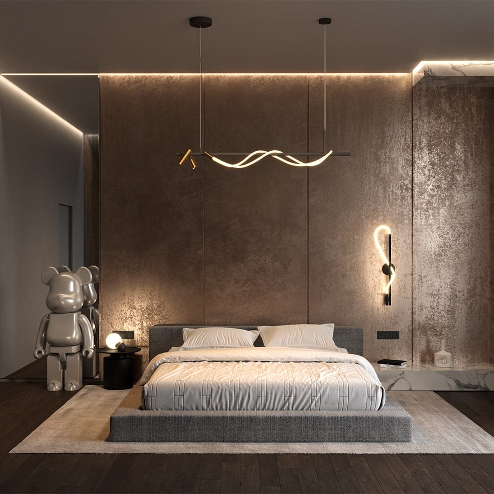 Czarna i złota lampa wisząca Tau LED z trzema punktami świetlnymi, umieszczona nad łóżkiem w nowoczesnej sypialni. Lampa ma falisty kształt, zawieszona na cienkich linkach w minimalistycznym wnętrzu z brązowymi ścianami i drewnianą podłogą.