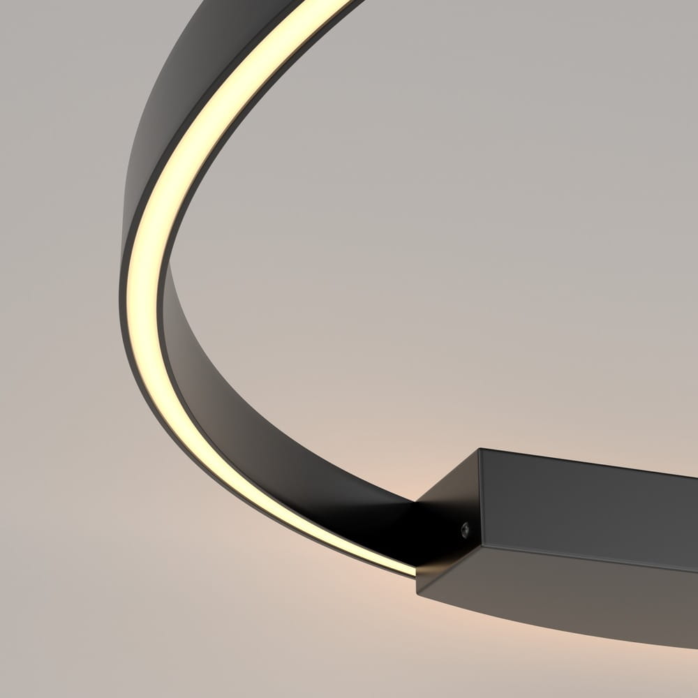 Czarny kinkiet Rim D80 LED z jednym źródłem światła. Okrągły, metalowy korpus z delikatnym podświetleniem LED, umieszczony na prostokątnej podstawie. Widoczny kształt w formie łuku, z jasnym światłem emitowanym z wewnętrznej krawędzi.