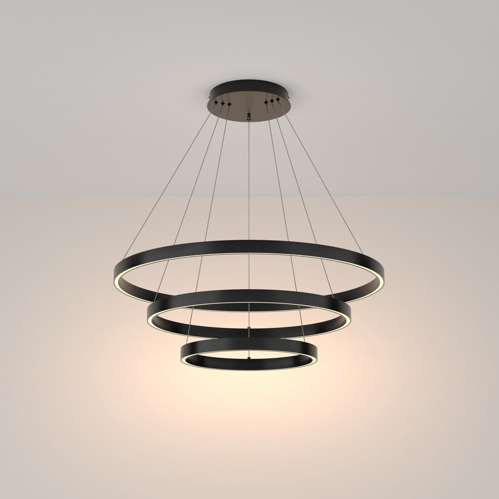 Czarna lampa wisząca Rim 3000K z trzema okrągłymi pierścieniami LED, zawieszona na cienkich linkach. Produkt ma nowoczesny design, z widocznym źródłem światła w obrębie pierścieni. Idealna do nowoczesnych wnętrz.