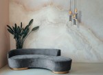 Lampa wisząca Palette 1-punktowa w kolorze czarnym z multikolorowymi akcentami, zawieszona na cienkich przewodach. W tle widoczna nowoczesna ściana w jasnych odcieniach oraz szara, welurowa kanapa o zaokrąglonym kształcie.