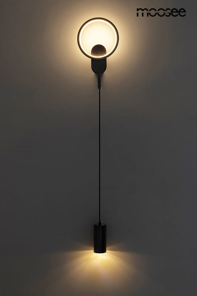 Kinkiet Como LED w kolorze czarnym z dwoma punktami świetlnymi. Górny element w formie okręgu z emitującym światłem diodowym, dolny cylindryczny z żarówką E27. Montowany na ścianie, elegancki design.