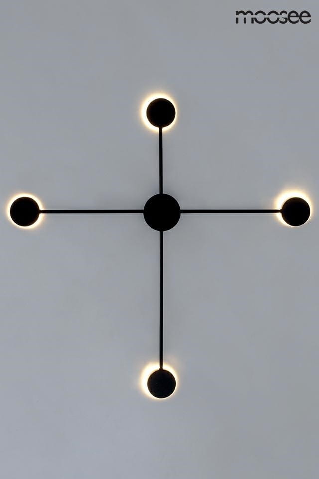 Czarny kinkiet LED Shadow 4 Close z czterema punktami świetlnymi, zamontowany. Ma minimalistyczny design z okrągłymi kloszami, emitującymi ciepłe światło. Ułożenie w kształcie krzyża, z centralnym punktem i równomiernie rozmieszczonymi lampami.