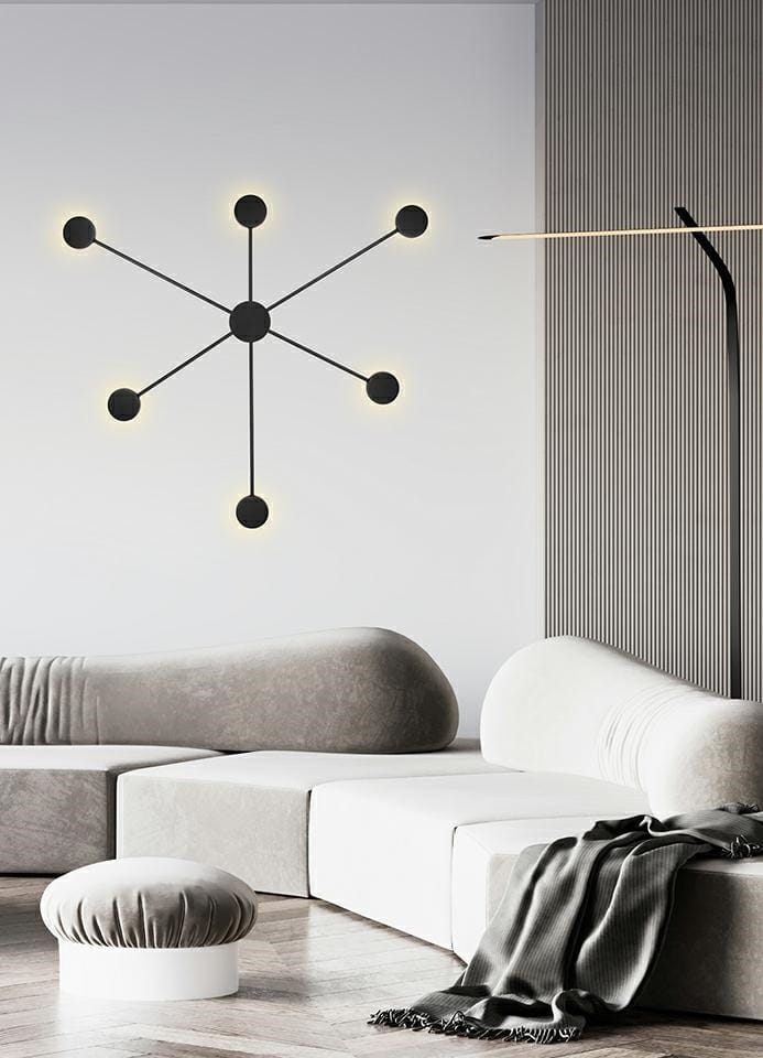 Kinkiet Shadow 6 Close LED w kolorze czarnym, z sześcioma punktami świetlnymi ułożonymi w geometryczny wzór. Montowany na ścianie, idealny do nowoczesnych wnętrz. Tło w jasnych odcieniach, z sofy w szaro-białych tonach.