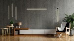 Czarny kinkiet Ombre 60 LED, 1-punktowy, zamontowany na ścianie w nowoczesnym wnętrzu. Oświetlenie w minimalistycznym stylu, obok drewniane meble, roślina i lampa stołowa. Tło z betonową fakturą.