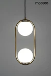 Lampa wisząca Aurelia Twin 2-punktowa, złota konstrukcja z metalowym ramieniem w kształcie owalu, z dwoma białymi kulistymi źródłami światła. Zawieszona na czarnym przewodzie, prezentująca nowoczesny design. Tło jasnoszare.