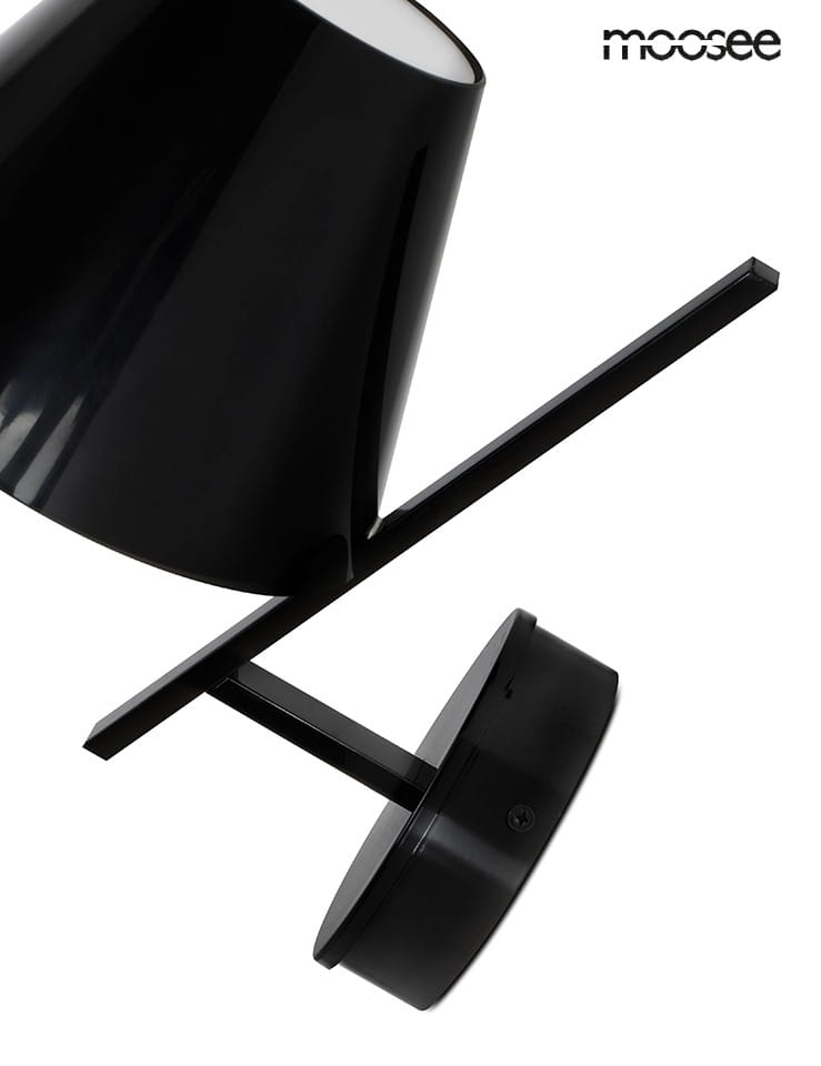 Kinkiet Mago 1-punktowy w kolorze czarnym, z cylindryczną osłoną lampy oraz prostokątnym mocowaniem. Ujęcie z boku, pokazujące elegancki design i minimalistyczną formę. Widoczny napis moosee w górnym rogu.