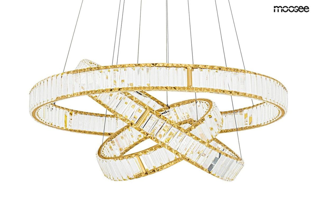 Złota lampa wisząca Liberty Triples LED o trzech punktach świetlnych, z przezroczystymi kryształowymi elementami, które tworzą efektowną spiralę. Produkt zawieszony na cienkich linkach, prezentujący nowoczesny design.