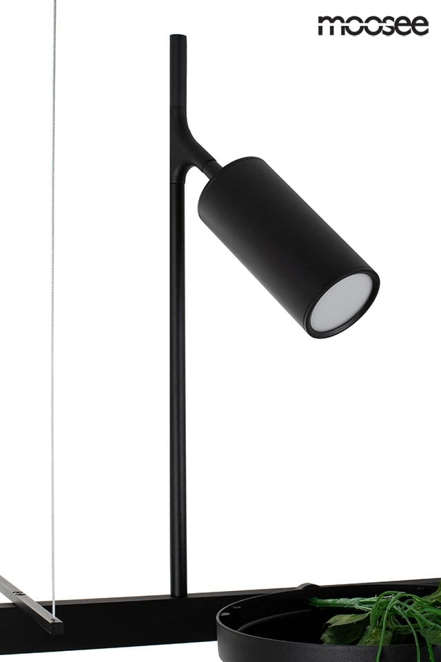 Czarna lampa wisząca LED Plant z dwoma punktami świetlnymi. Cylindryczny klosz z matowego materiału, zamontowany na cienkiej stalowej rurze. Widoczna doniczka z rośliną w tle. Prosty design, idealna do nowoczesnych wnętrz.