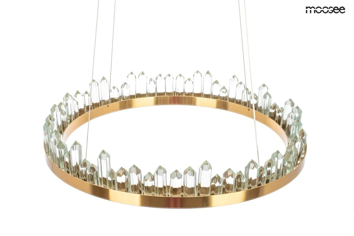 Złota lampa wisząca Nenufar LED z przezroczystymi kryształkami ułożonymi w okrąg. Lampa ma metalowy pierścień z wykończeniem w kolorze złotym, zawieszona na cienkich linkach. Kryształy mają różne wysokości, co tworzy efektowne wzornictwo.