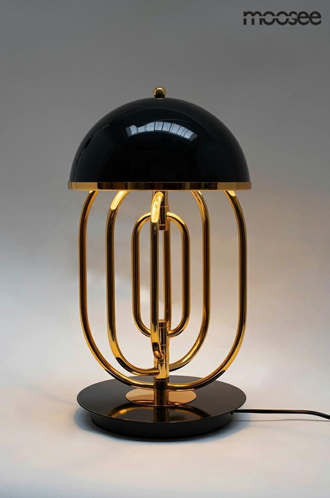 Lampa stołowa Bottega 2-punktowa w kolorze złotym i czarnym. Posiada okrągłą, czarną podstawę oraz zaokrąglony klosz. Złote metalowe elementy tworzą unikalny wzór, podkreślając nowoczesny design. Ujęcie frontalne.