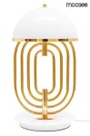 Lampa stołowa Bottega 2-punktowa w kolorze złotym i białym. Posiada okrągłą podstawę, metalową konstrukcję z falistymi złotymi rurkami oraz biały klosz w formie półkuli. Ujęcie frontalne, produkt stoi na płaskiej powierzchni.