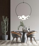 Czarna lampa wisząca Rocio z 14 punktami świetlnymi, zawieszona nad okrągłym stołem, w nowoczesnym wnętrzu. Obok znajdują się stylowe krzesła i donica z kaktusem, na tle jasnej ściany i drewnianej okładziny.
