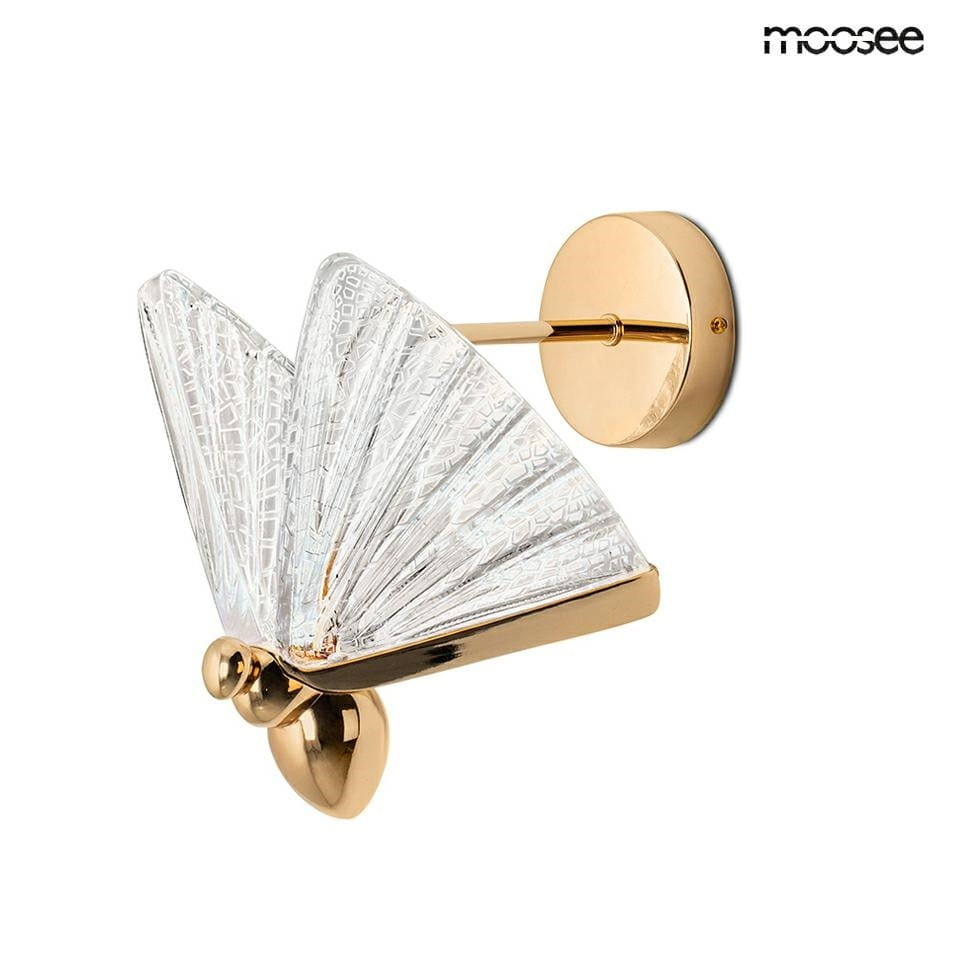 Kinkiet Butterfly M LED w złotym wykończeniu, z przezroczystym kloszem w kształcie motyla. Widać okrągły uchwyt montażowy oraz elegancką, teksturowaną powierzchnię klosza. Produkt zamontowany na ścianie.