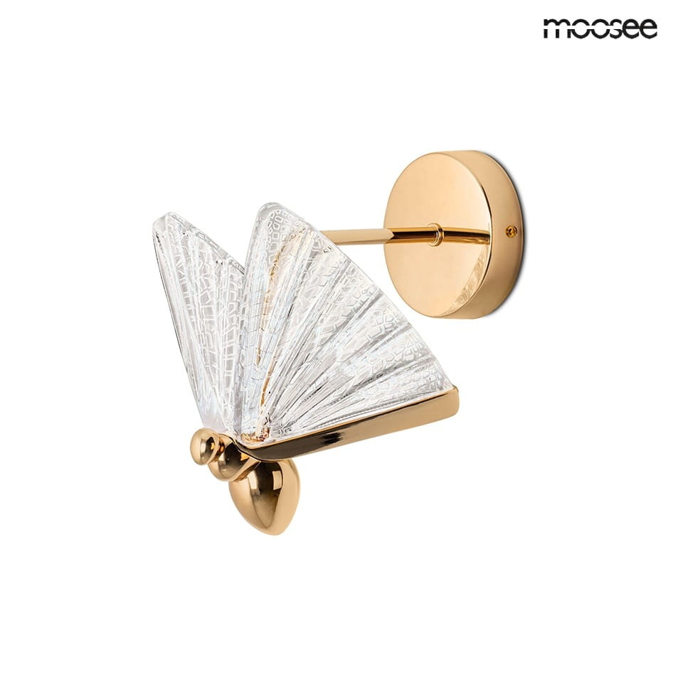 Kinkiet Butterfly S LED w kolorze złotym, z przezroczystym kloszem w kształcie motyla. Złota, okrągła baza oraz elegancka, strukturalna faktura klosza. Produkt zamontowany na ścianie, z widocznym detalem mocującym.