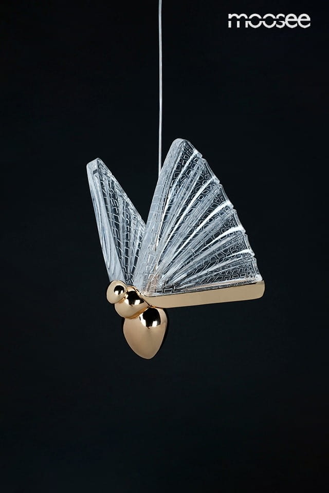 Lampa wisząca Butterfly M LED w kolorze złotym, z przezroczystymi skrzydłami przypominającymi motyla, zawieszona na cienkim przewodzie. Widoczna złota baza z kulistymi detalami. Tło czarne, podkreślające elegancki design.